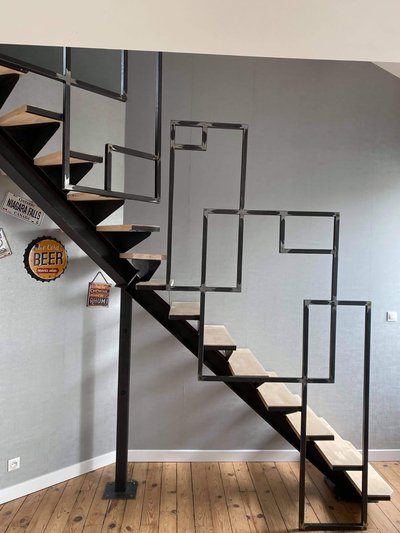 Escalier acier noir avec rampe en bois courbe – Détail d'assemblage artisanal et finition