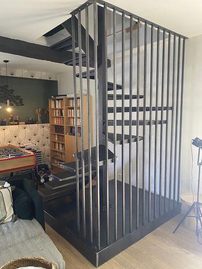 Cage d'escalier hélicoïdal et garde-corps à barreaudage acier – Vue d'ensemble dans un salon