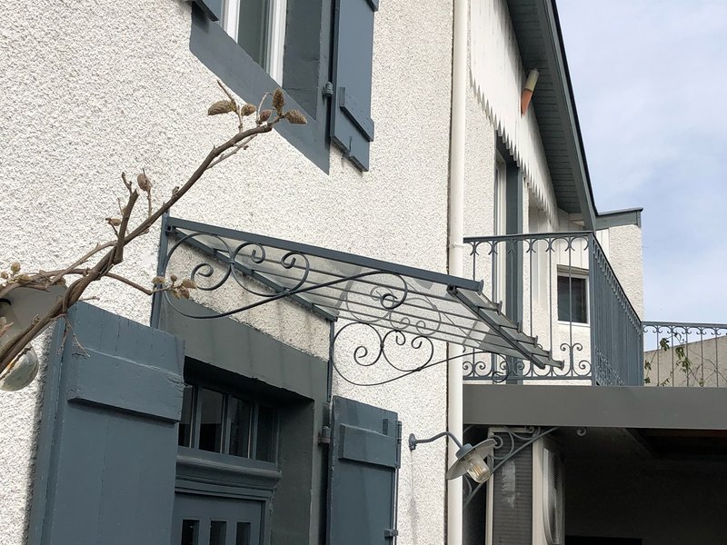 Marquise en acier et verre feuilleté sur mesure à Pau, protégeant l'entrée d'une maison avec structure acier soudée